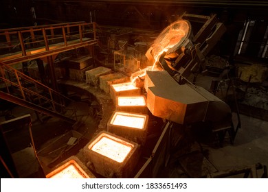 Tank pours liquid metal in the molds by carousel machine - Shutterstock ID 1833651493