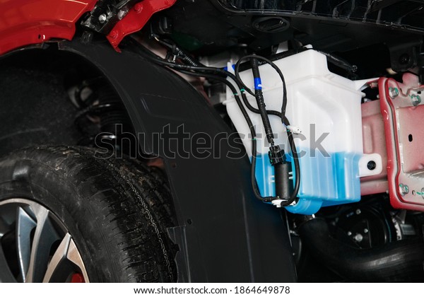 a tank with washer fluid and a motor for supplying\
fluid in the car body