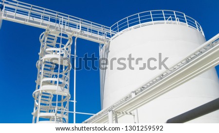 The tank with water and a ladder. Oil refinery. Equipment for primary oil refining.