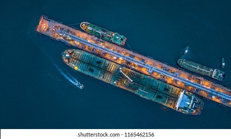 Tanker ship loading and unloading oil and gas storage at industrial port, Business import export petrol chemical oil and gas LNG tanker ship transportation, Loading arm oil and gas offshore platform. 