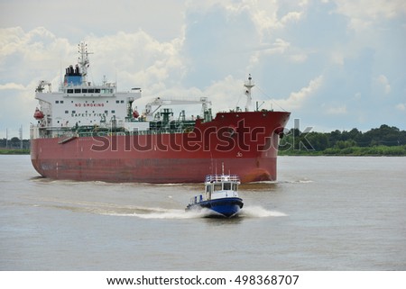 A tanker and a speeding motor launch on the Mississippi river near New Orleans in Louisiana.