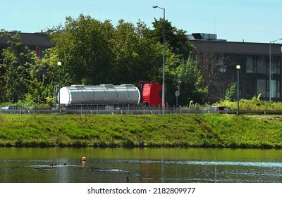 A Tanker Truck And Cars On The Road Pass Over The Water