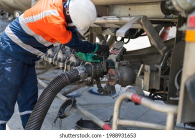 A Tanker Truck Driver Delivers Gasoline To A Gas Station