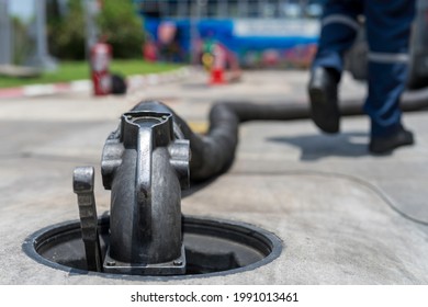 A Tanker Truck Driver Delivers Gasoline To A Gas Station