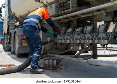 A Tanker Truck Driver Delivers Gasoline To A Gas Station