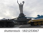 tanks in front of a statue