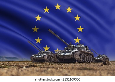 Tanks Lined Up In Front Of A European Union Or EU Flag. Several Military Army War Battle Tank Vehicles On The Terrain Ready To Attack