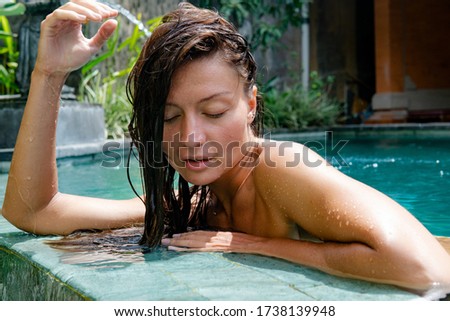 tanned girl in a swimsuit bathes in a pool. Holidays in Indonesia and Southeast Asia