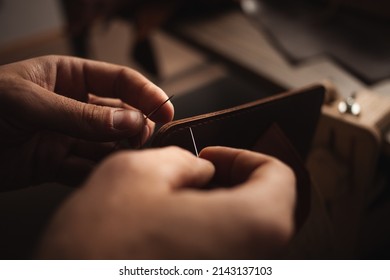 tanner stitches makes leather purse. DIY instruction, indoors - Powered by Shutterstock