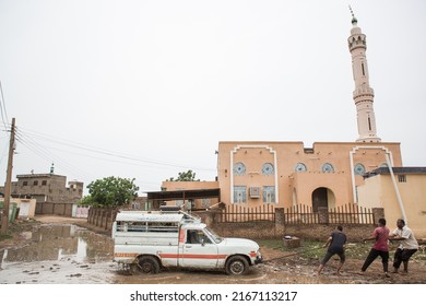 TANNOOB, SUDAN - SEPTEMBER 13, 2021: Sudanese Farmers Push A Car Out Of A Puddle Of Water In Front Of A Mosque In Tannoob. Sunni Muslims Account For The Overwhelming Majority Of Sudan's Population. 