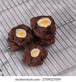 A tantalizing close-up shot captures a stack of intensely dark chocolate cookies, rich with cocoa flavor and flecked with chocolate chips. These decadent, homemade treats are set against a bright