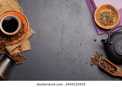 A tantalizing display of roasted coffee beans and dry tea leaves, accompanied by an espresso coffee cup and a teapot. Flat lay with copy space - Powered by Shutterstock