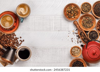 A tantalizing display of roasted coffee beans and various dry tea leaves, accompanied by an espresso coffee cup and a teapot. Flat lay with copy space - Powered by Shutterstock