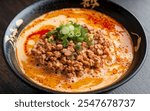 Tantanmen: Spicy ramen with a creamy sesame broth, topped with ground pork, green onions, and chili oil, inspired by Sichuan-style flavors.