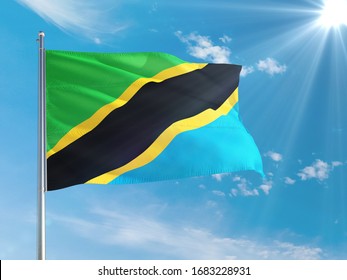 Tanzania national flag waving in the wind against deep blue sky. High quality fabric. International relations concept.