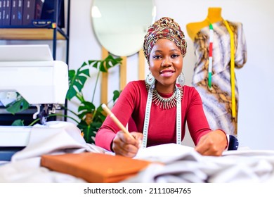 tanzanian woman with snake print turban over hear working in dressmaking shop