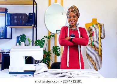 tanzanian woman with snake print turban over hear working in fashion house - Powered by Shutterstock