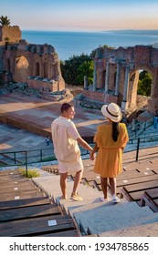 Taormina Sicily, couple watching sunset at the Ruins of the Ancient Greek Theater in Taormina, Sicily. couple mid age on vacation Sicilia