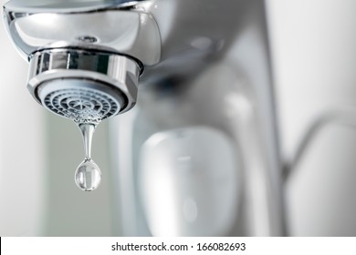 Tap closeup with dripping water-drop. Water leaking, saving concept.