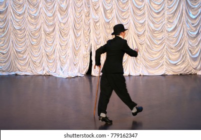 Tap Dance With A Cane In A Black Hat. Dance Step. A Man Is Dancing On Stage