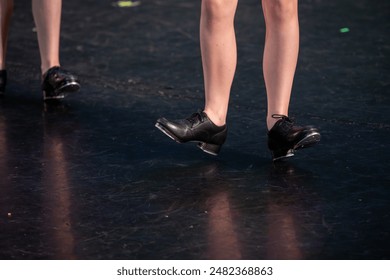 Tap dancing on stage - a close-up of tap shoes on a worn stage. - Powered by Shutterstock