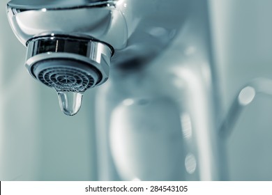 Tap with dripping waterdrop. Water leaking, saving.