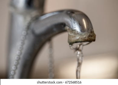 Tap Limescale. Selective Focus On The Hard Water Deposit Of A Running Kitchen Or Bathroom Faucet.