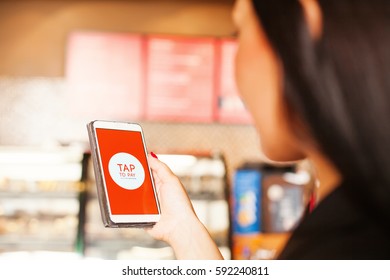 Tap To Pay On Mobile Phone Technology. Woman Paying With Mobile Phone