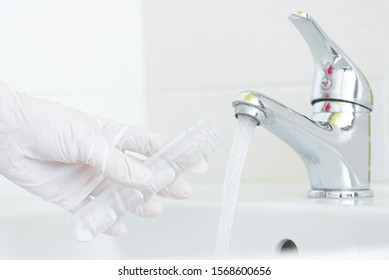 Tap Water Analysis Quality Control Concept. Hand With A Flask And Water Tap Ckose Up.