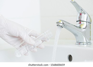 Tap Water Analysis Quality Control Concept. Hand With A Flask And Water Tap Ckose Up.