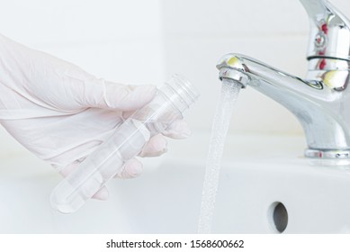 Tap Water Analysis Quality Control Concept. Hand With A Flask And Water Tap Ckose Up.