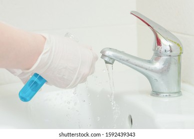 Tap Water Analysis Quality Control Concept. Hand With A Flask And Water Tap Ckose Up.