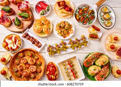 Tapas mix and pinchos food from Spain recipes also pintxos on a white wood board