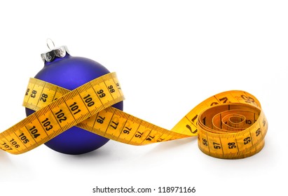 Tape Measure Around A Bauble Concept Symbolizing Christmas Weight Gain From Eating Too Much Food.