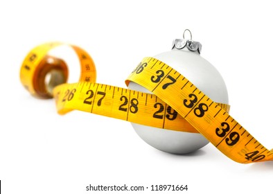 Tape Measure Around A Bauble Concept Symbolizing Christmas Weight Gain From Eating Too Much Food.