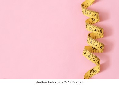 tape measure for obese people on a pink background soft focus - Powered by Shutterstock