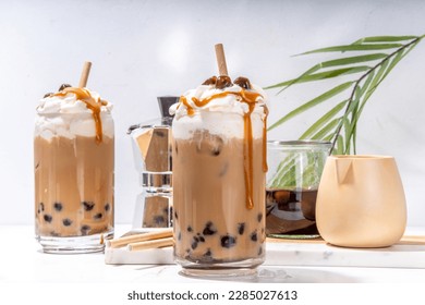 Tapioca boba balls coffee frappe, asian trendy cold coffee drink with tapioca balls and whipped coconut cream and caramel sauce