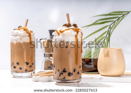 Tapioca boba balls coffee frappe, asian trendy cold coffee drink with tapioca balls and whipped coconut cream and caramel sauce