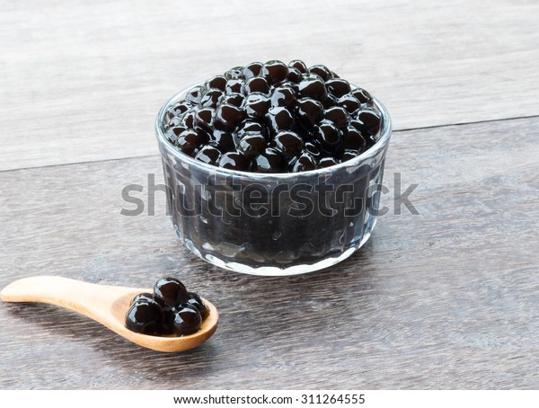 Tapioca Pearl , Bubble topping for tea or\
other beverage, in a cup, place on wooden\
table