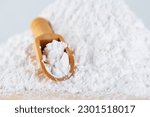 Tapioca starch or flour powder. White powdered tapioca starch in a wooden scoop, dry cassava root.