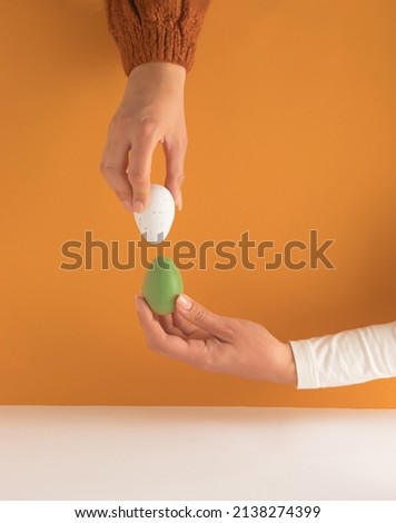 Tapping the Easter eggs - egg knocking game. Egg fight illustration photo. Minimal Easter composition.