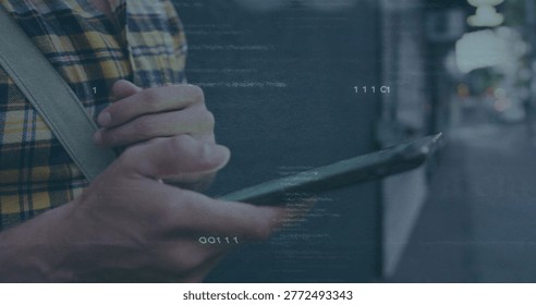 Tapping man using phone on city sidewalk at night, showing yellow-blue plaid shirt and canvas strap. Device, urban, street, bokeh, touchscreen, commuter, silhouette