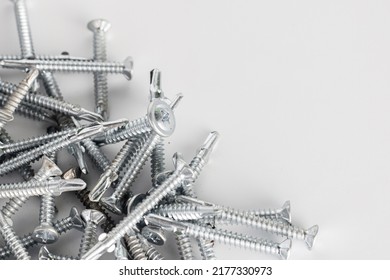 Tapping screws made of steel on white and gray background, metal screw, iron screw, chrome screw, screws as a background, wood screw, concept industry. copy space for text.