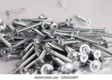 Tapping screws made of steel on Gray background, metal screw, iron screw, chrome screw, screws as a background, wood screw, concept industry. copy space for text.