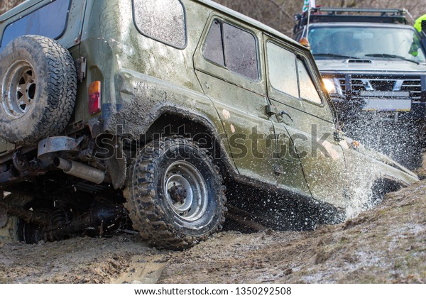 Taraclia, Moldova - 23. 02. 2019: Rally on Russian SUVs\
in the mud in winter, Trapped all-terrain vehicle pulled out of the\
river    
