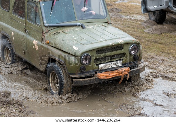 Taraclia, Moldova - 23. 02. 2019: Rally on Russian SUVs
in the mud in winter, Trapped all-terrain vehicle pulled out of the
river    