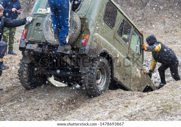 Taraclia, Moldova - 23. 02. 2019: Rally on Russian
SUVs in the mud in winter, Trapped all-terrain vehicle pulled out
of the river