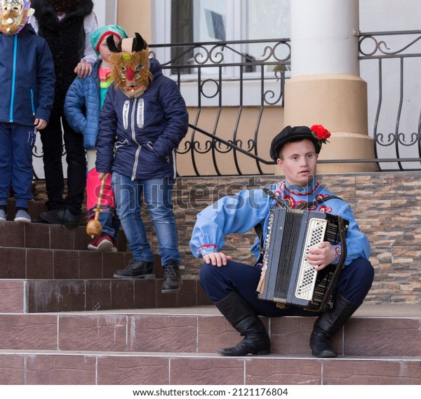 Taraclia, Moldova,10.03.2019. Socialization of\
people with disabilities. A man with down syndrome in a national\
costume and with an accordion. Inclusion (disability\
rights).Carnival of\
mummers.