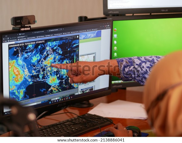 Tarakan,\
Indonesia. 03-25-2022. Indonesians meteorologists monitor radar\
displays. Weather forecast in a\
office.