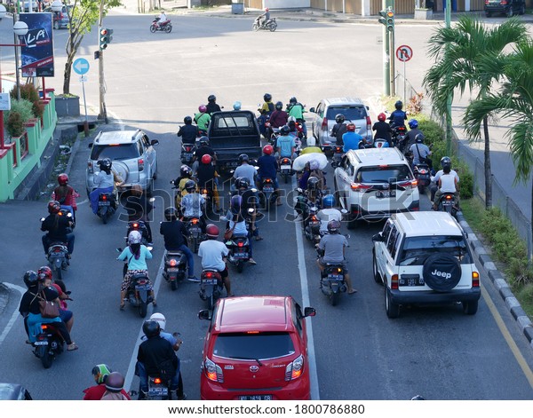 Tarakan/Indonesia-August 22,2020: Traffic waits at a\
busy junction in the city centre on August 22, 2020 in Tarakan,\
Indonesia. View from above.\
